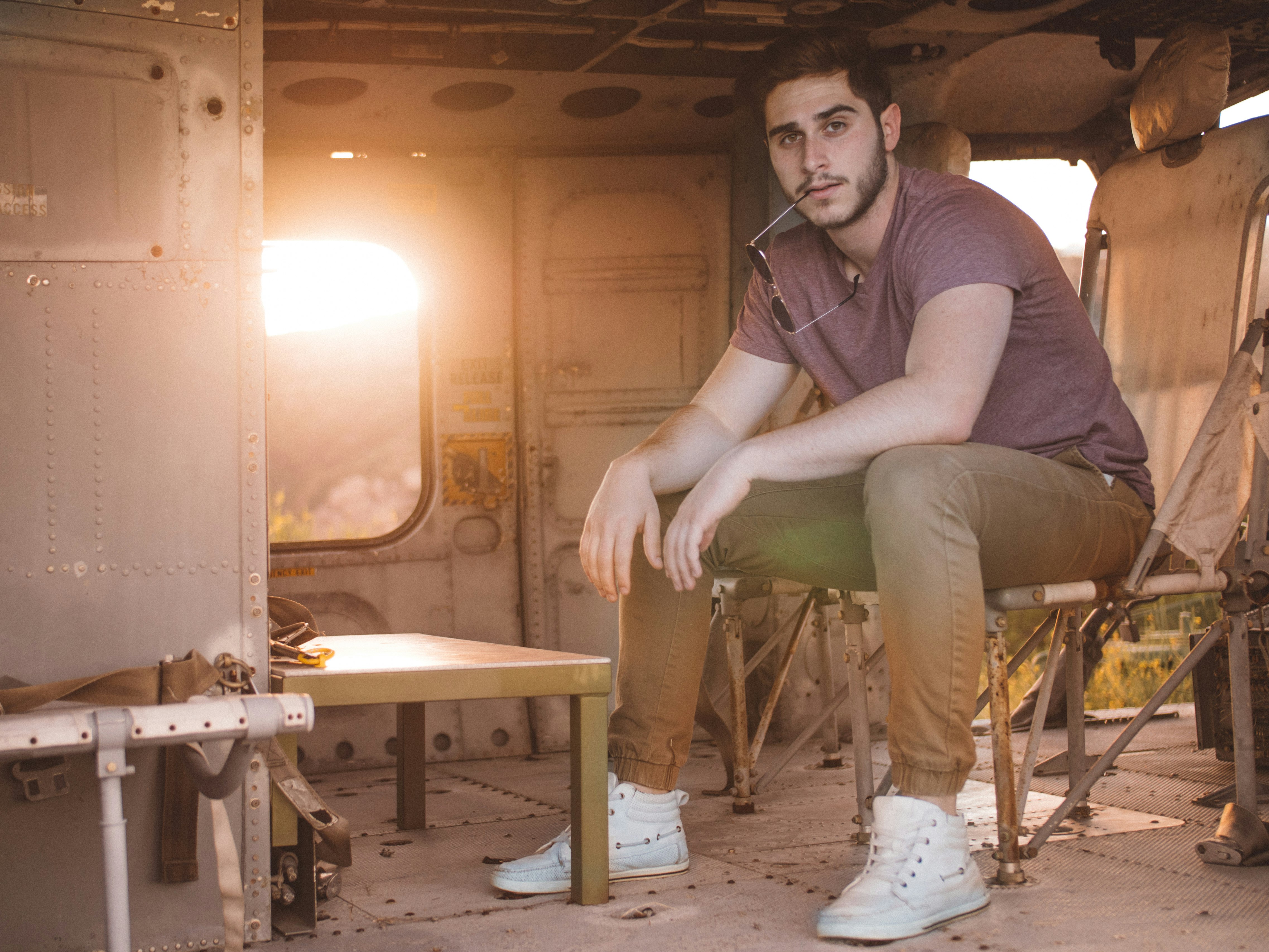 man in gray shirt sitting on brown chair